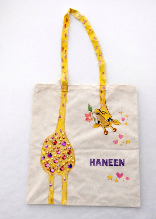 Tote bag with a giraffe design and 'HANEEN' text on a white background